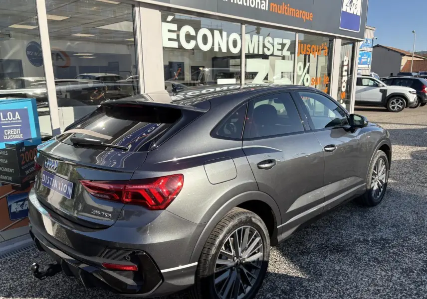 Audi Q3 Sportback gris Daytona vue 3/4 arrière droit avec jantes 20 branches et crochet d'attelage visible