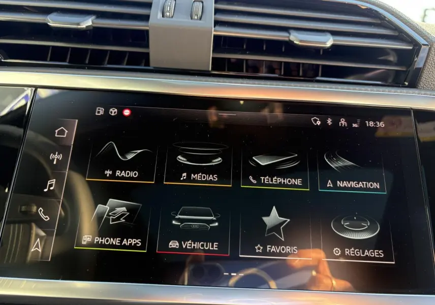 Écran tactile central de l'Audi Q3 Sportback 2025 affichant les menus multimédia et navigation, intérieur moderne noir.