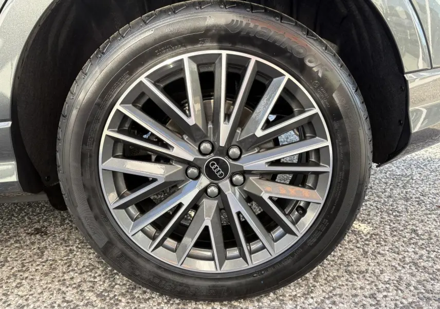 Gros plan sur la jante en aluminium 20 branches en V gris contrasté du côté gauche d'un Audi Q3 Sportback gris Daytona.