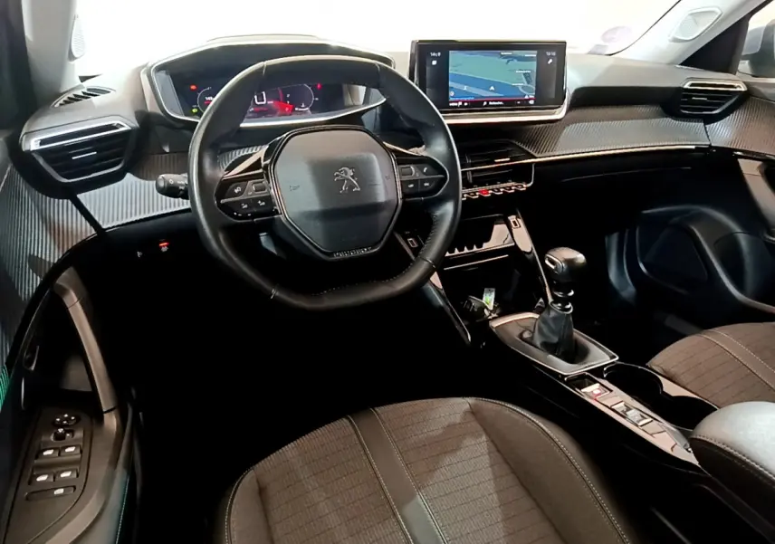 Intérieur du Peugeot 2008 PureTech 130, vue côté conducteur sur volant cuir et écran tactile de navigation.
