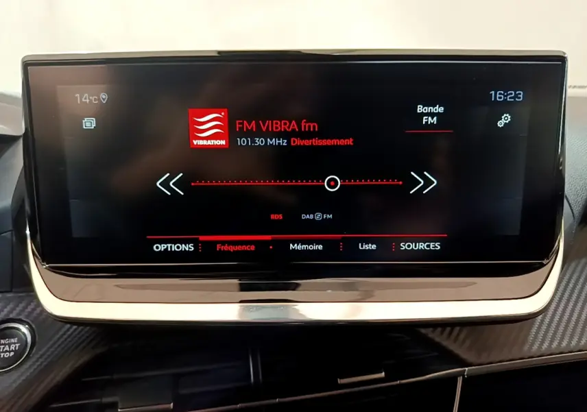 Écran tactile central de 10 pouces affichant la radio FM dans l’habitacle d’une Peugeot 2008 gris clair.