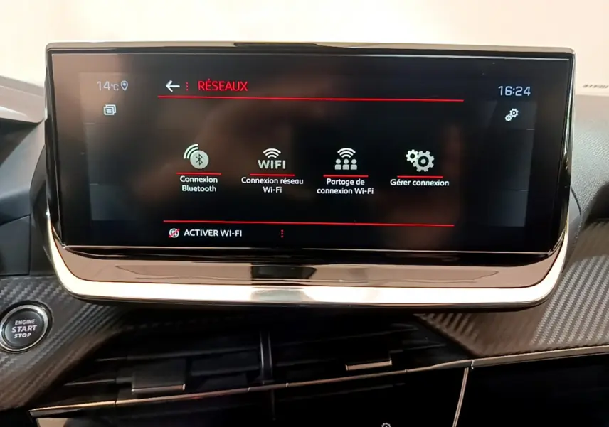 Écran tactile 10 pouces du tableau de bord du Peugeot 2008 gris clair, avec menu réseaux et bouton démarrage visible.