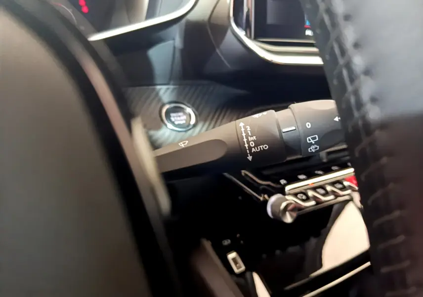 Gros plan sur la manette d'essuie-glace côté gauche du tableau de bord gris carbone d'un Peugeot 2008 2021.