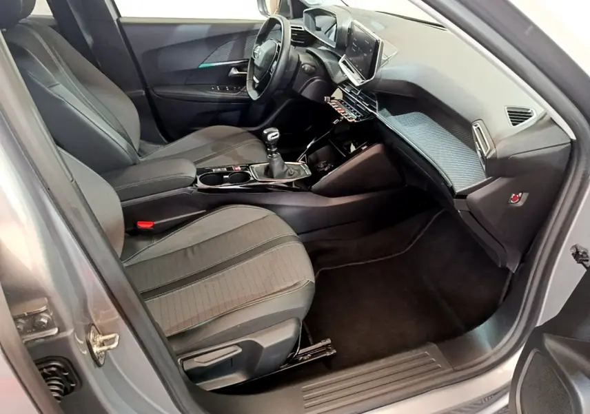 Vue intérieure côté conducteur du Peugeot 2008 gris clair 2021 avec tableau de bord moderne et écran tactile central.