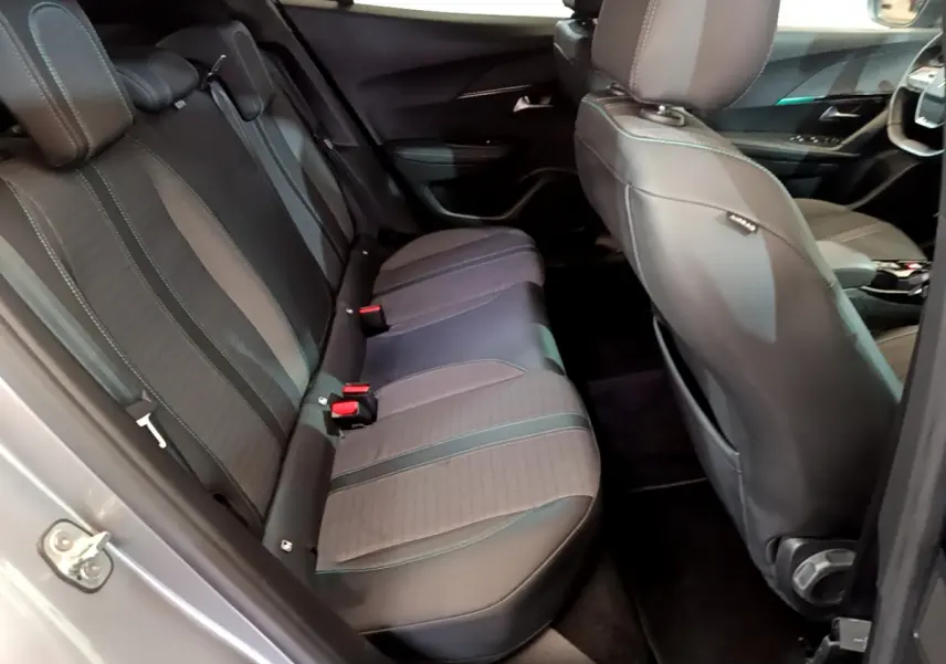 Vue intérieure côté gauche montrant la banquette arrière et les sièges avant du Peugeot 2008 gris clair 2021.