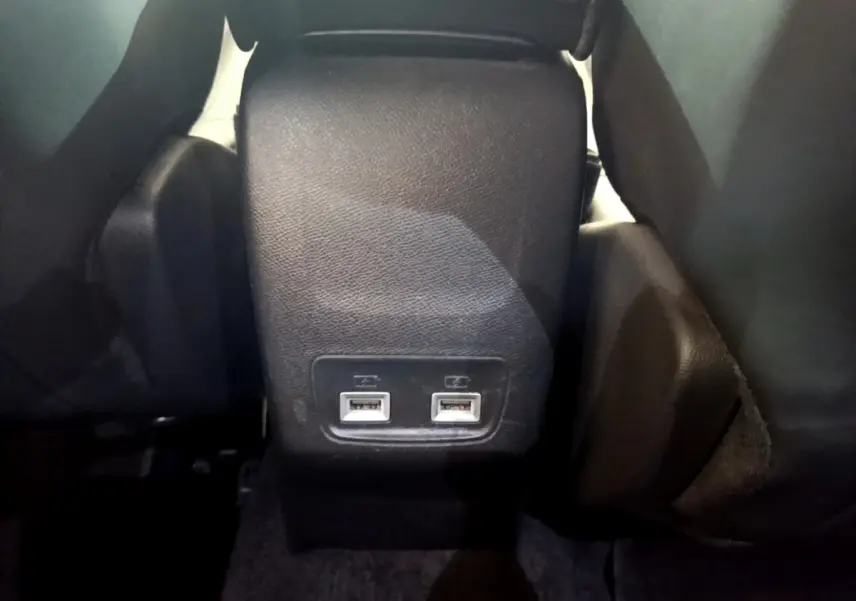 Prise double USB arrière noire entre les sièges dans l'habitacle du Peugeot 2008 gris clair 2021.