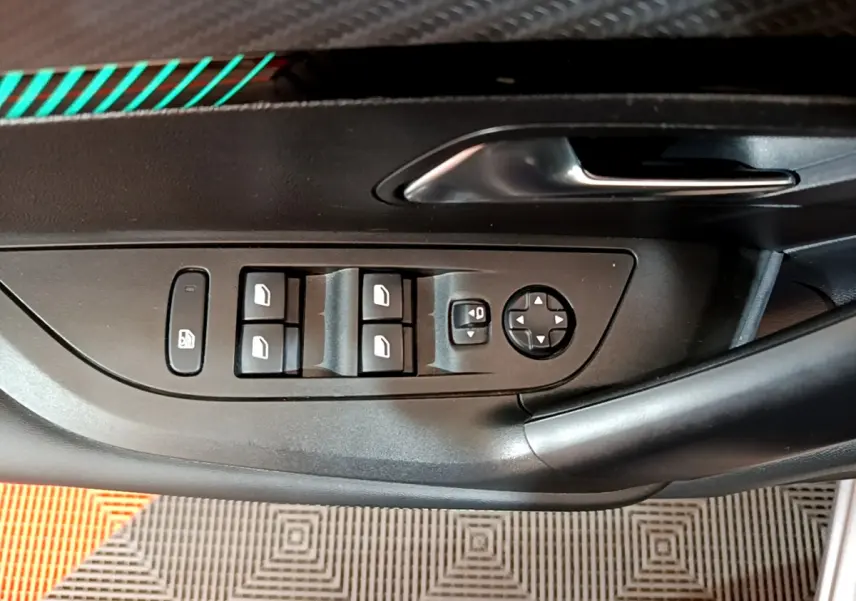 Gros plan sur la commande des vitres et rétroviseurs côté gauche d'une Peugeot 2008 gris clair, intérieur noir.