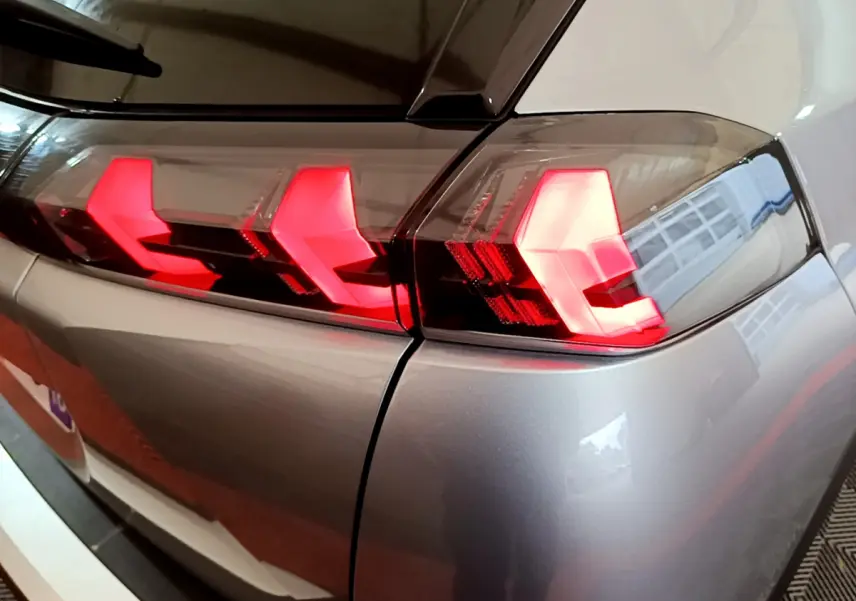 Gros plan sur les feux arrière LED rouges du côté gauche d'un Peugeot 2008 gris clair 2021.