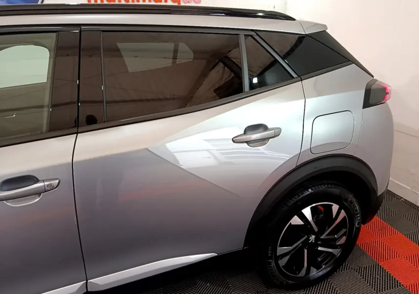 Vue côté droit arrière du Peugeot 2008 gris clair avec jante noire et poignées de porte intégrées.