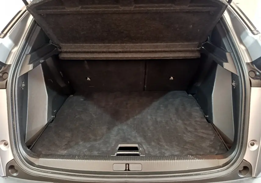 Coffre ouvert du Peugeot 2008 gris clair, vue arrière montrant l'espace de chargement vide et la tablette de séparation.