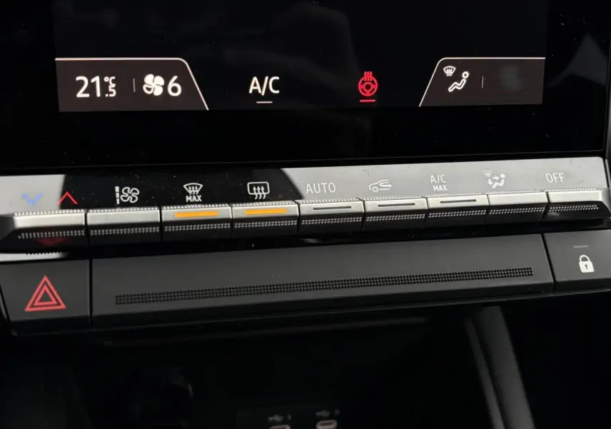 Vue rapprochée du tableau de bord du Renault Captur blanc nacré 2025, montrant les commandes de climatisation et l'écran digital.