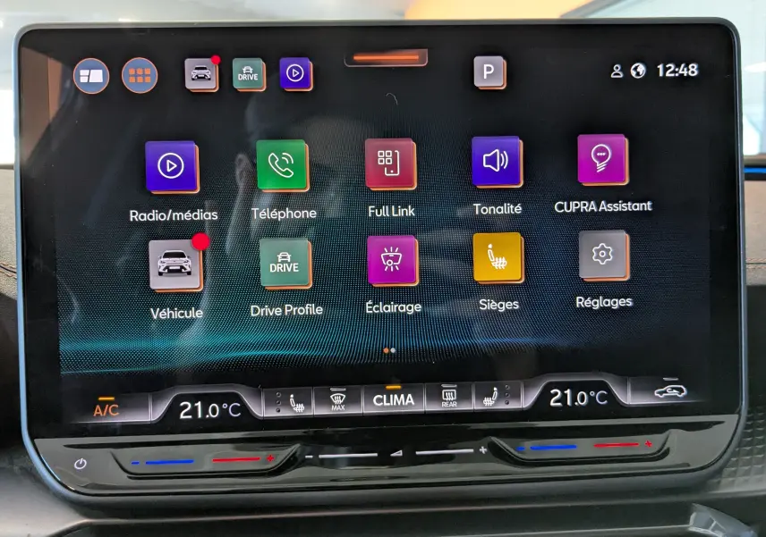 Écran tactile central du CUPRA Formentor 2025 affichant les options multimédia, climatisation à 21°C et réglages de sièges chauffants.