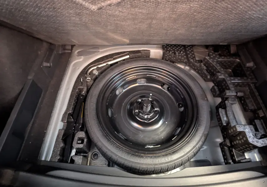 Vue plongeante sur la roue de secours noire dans le coffre du CUPRA Formentor gris magnétique 2025.