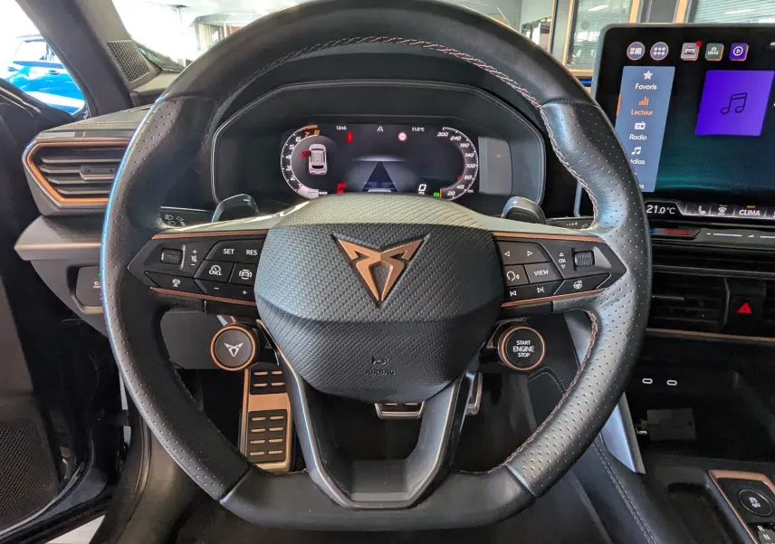 Vue rapprochée du volant en cuir perforé noir avec logo CUPRA et tableau de bord numérique du Formentor gris magnétique 2025.