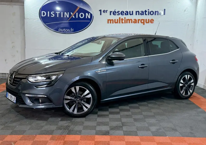 Renault Mégane Intens gris foncé vue de profil droit en intérieur, avec jantes alliage et phares LED allumés.
