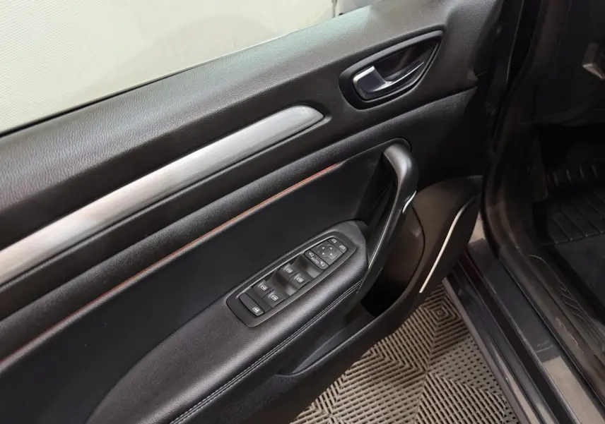 Vue rapprochée de la porte avant gauche noire de la Renault Mégane Intens 2019 avec commandes des vitres et rétroviseurs.