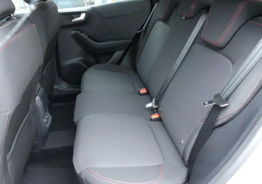 Vue intérieure côté droit des sièges arrière noirs avec surpiqûres rouges du Ford Puma 2025 gris métallisé.
