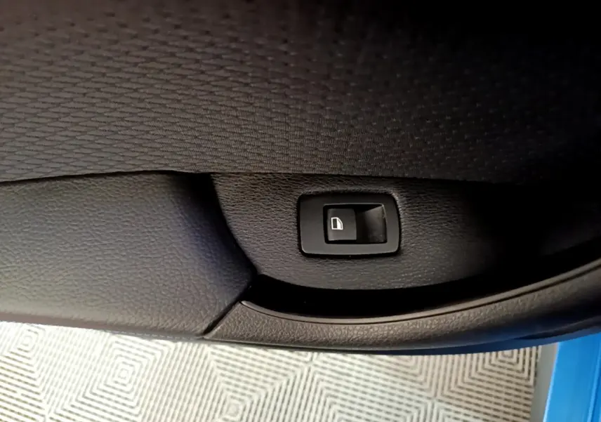 Détail de la commande de verrouillage sur la porte intérieure côté gauche d’un BMW X2 bleu 2019.