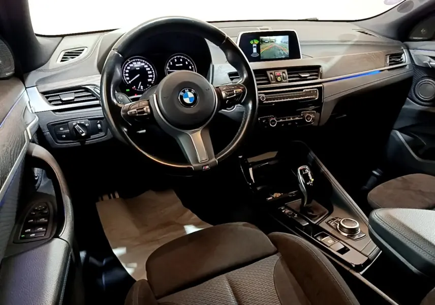 Vue intérieure côté conducteur du BMW X2 sDrive20i M Sport 2019, montrant le volant cuir, tableau de bord et écran tactile.
