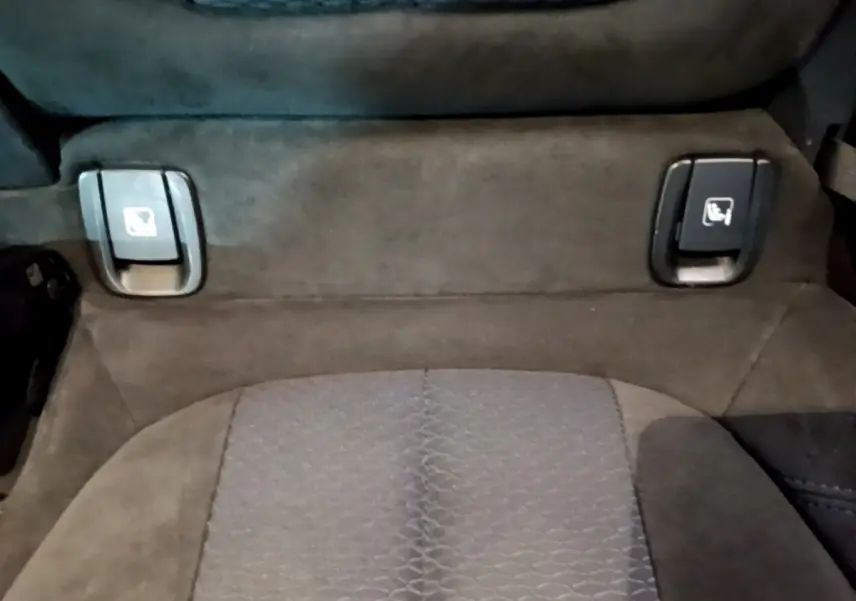 Détail des commandes de rabattement individuel des sièges arrière sur banquette tissu gris foncé de BMW X2 sDrive20i M Sport.