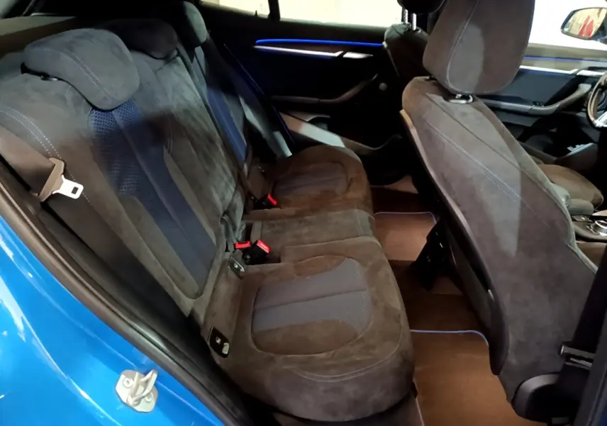 Vue intérieure côté gauche sur la banquette arrière en tissu noir et bleu du BMW X2 sDrive20i M Sport bleu 2019.