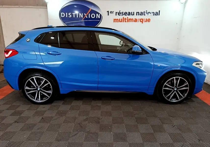 Vue latérale droite d'un BMW X2 bleu 2019 sDrive20i M Sport avec jantes alliage et vitres teintées.