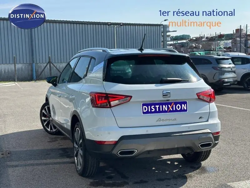 Vue 3/4 arrière droite du SEAT Arona 2025 blanc Candy avec toit noir Minuit et jantes alliage distinctives.