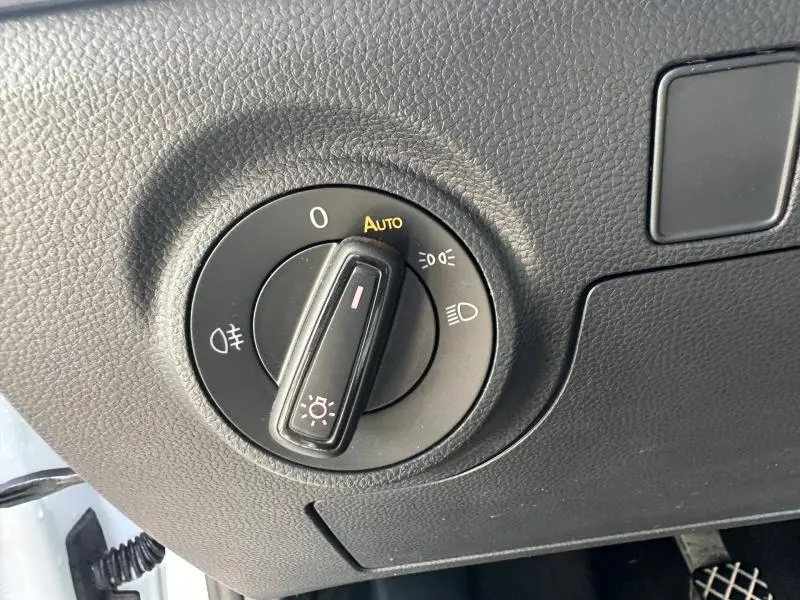 Gros plan sur le sélecteur de phares noir dans l’habitacle du SEAT Arona 2025, avec finition texturée du tableau de bord.