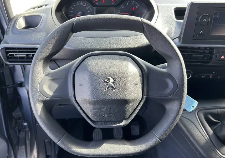 Vue rapprochée du volant Peugeot noir et du tableau de bord du DANGEL PARTNER 4x4 gris Artense de 2025.