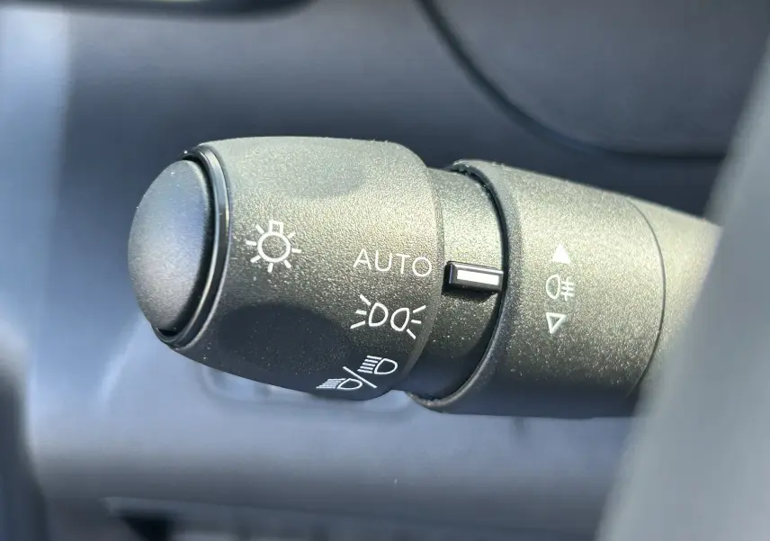 Gros plan sur la commande d'éclairage du DANGEL Partner 4x4 gris Artense, montrant les réglages automatiques et feux antibrouillard.