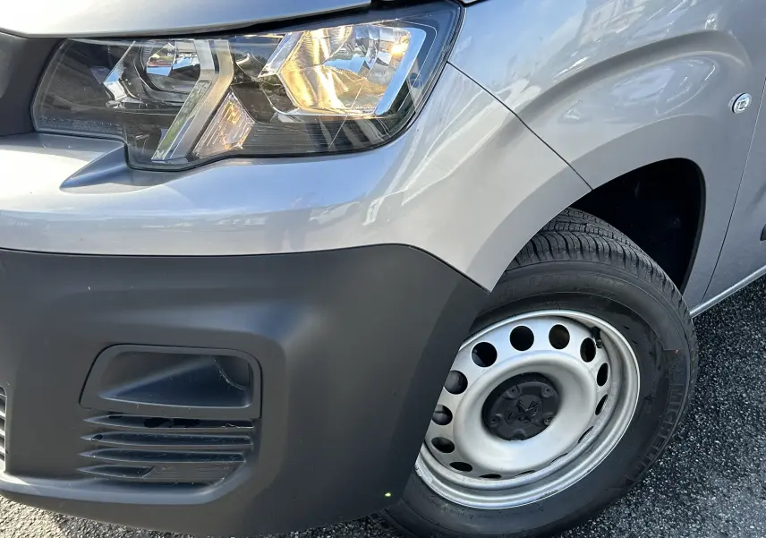 Gros plan sur l'avant droit gris Artense du DANGEL PARTNER 4x4 avec phare allumé et jante acier simple.