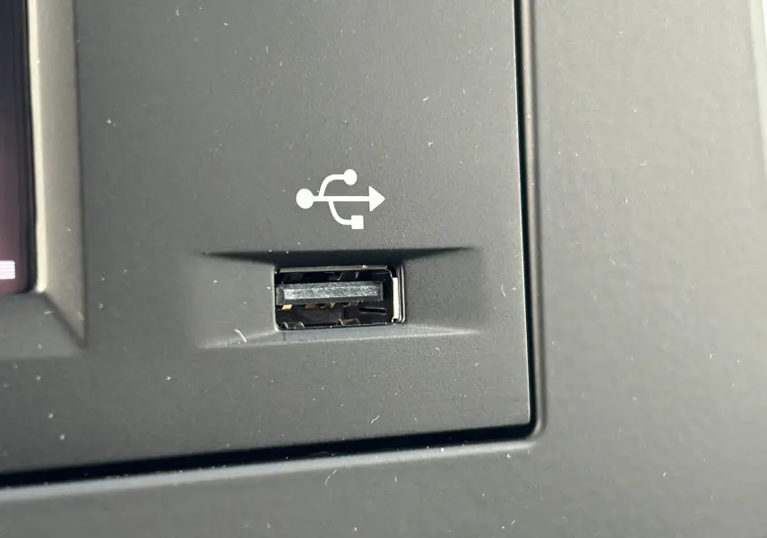Prise USB intégrée sur le tableau de bord noir du DANGEL Partner 4x4 gris Artense, vue rapprochée intérieure.
