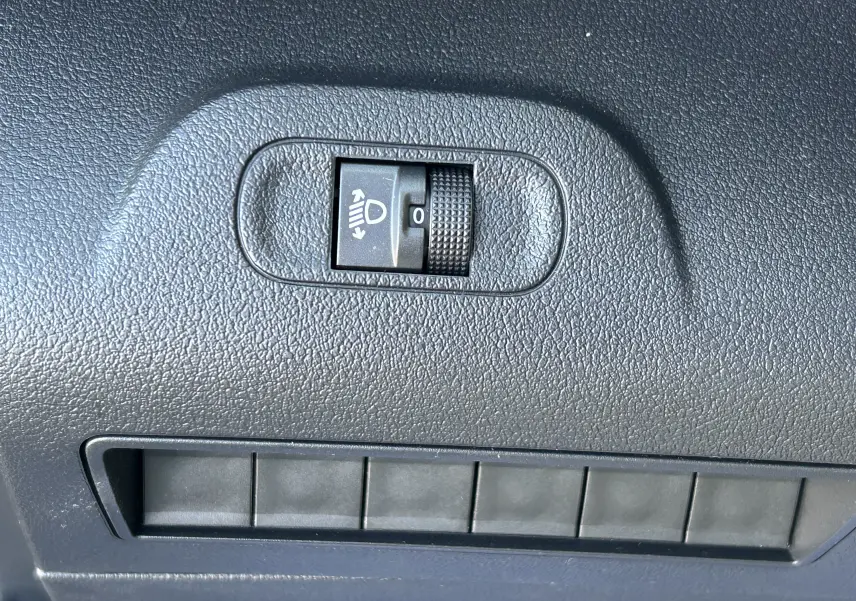 Molette de réglage de l'inclinaison des phares sur tableau de bord noir du DANGEL Partner gris Artense 2025.