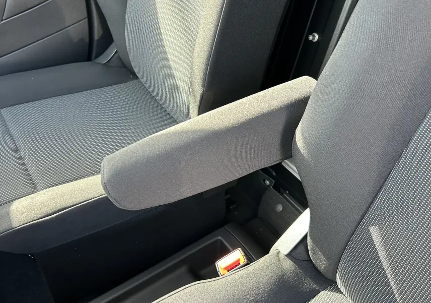 Gros plan sur l'accoudoir central et les sièges en tissu gris foncé de l'habitacle du DANGEL Partner 4x4.