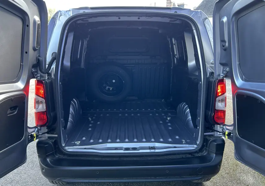 Vue arrière du DANGEL PARTNER 4x4 gris Artense avec portes ouvertes dévoilant l'espace de chargement vide et une roue de secours.