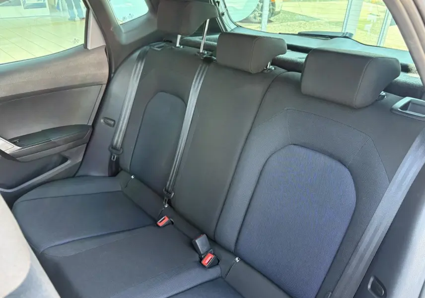 Vue latérale gauche de la banquette arrière noire textile du SEAT Arona 2024 avec appuie-têtes et ceintures visibles.
