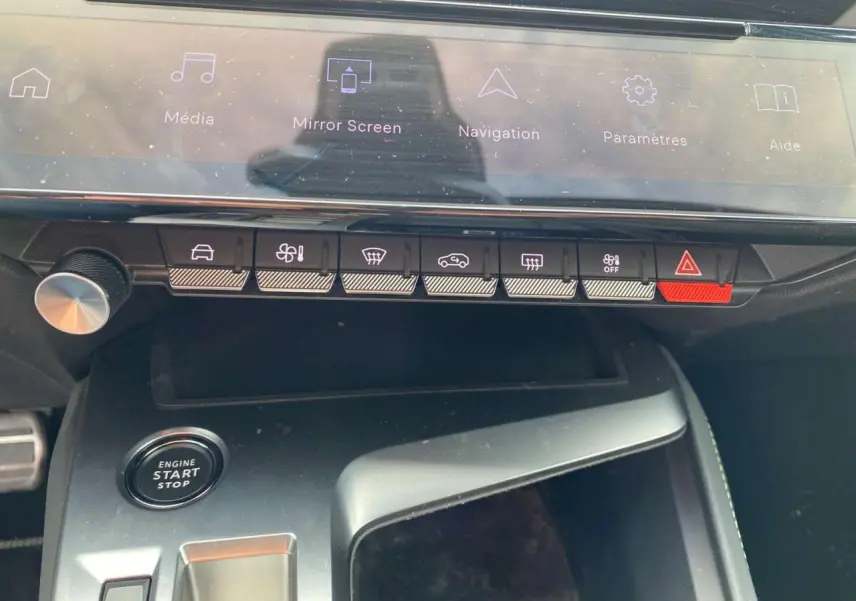 Gros plan sur la console centrale de la Peugeot 308 2023, montrant les commandes tactiles et le bouton start/stop.