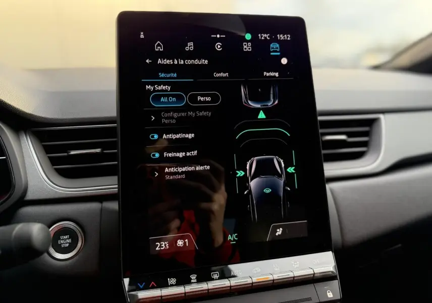 Vue intérieure centrée sur l’écran tactile vertical Open R-Link 10,4" du Renault Captur 2025, avec commandes de sécurité affichées.