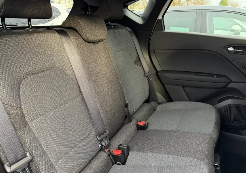 Vue intérieure côté droit des sièges arrière gris foncé du Renault Captur 2025 avec ceintures et appuie-têtes visibles.