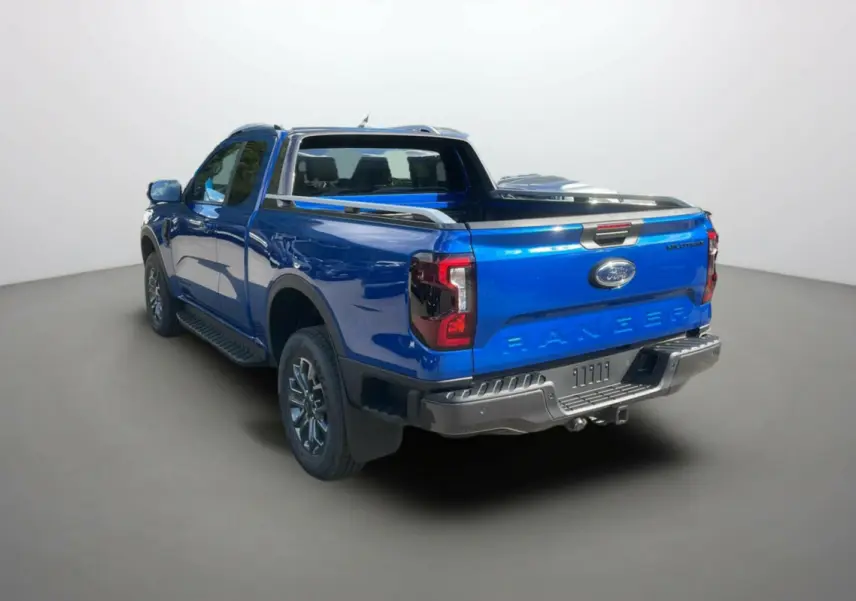Vue 3/4 arrière droite du Ford Ranger Wildtrak bleu lightning avec arceau sport et attelage visible.