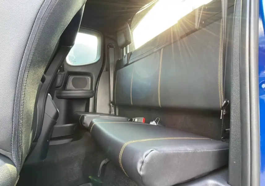 Vue intérieure arrière côté droit du Ford Ranger Wildtrak 2025 bleu lightning, banquette en cuir noir avec surpiqûres jaunes.