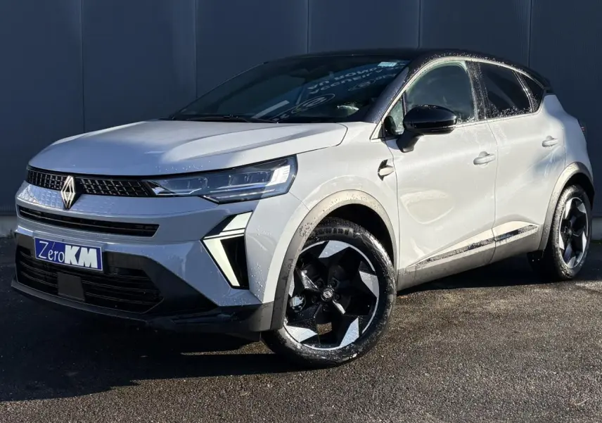Vue 3/4 avant droit du Renault Captur 2025 gris Rafale avec toit noir et jantes aluminium noires distinctives.