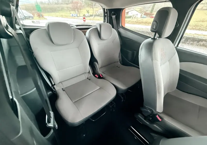 Vue intérieure arrière montrant les sièges gris en tissu de la Renault Twingo II 2009, côté gauche et droit visibles.