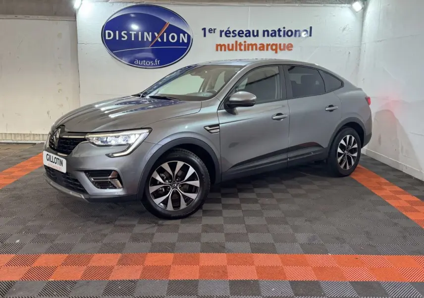 Renault Arkana Business E-TECH 145 gris foncé en 3/4 avant droit, avec jantes bicolores et phares LED allumés.