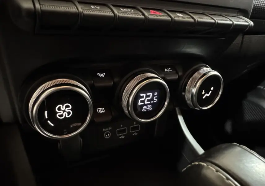 Gros plan sur les commandes de climatisation avec affichage digital à 22,5°C dans l’habitacle noir du Renault Arkana Business E-TECH.