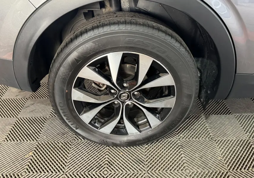 Gros plan sur la roue avant droite avec jante alliage bicolore du Renault Arkana gris foncé Business E-TECH 145.