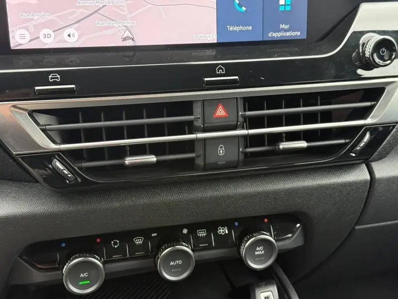 Détail intérieur du tableau de bord de la Citroën C4 X 2024, montrant les aérateurs noirs et les commandes de climatisation.