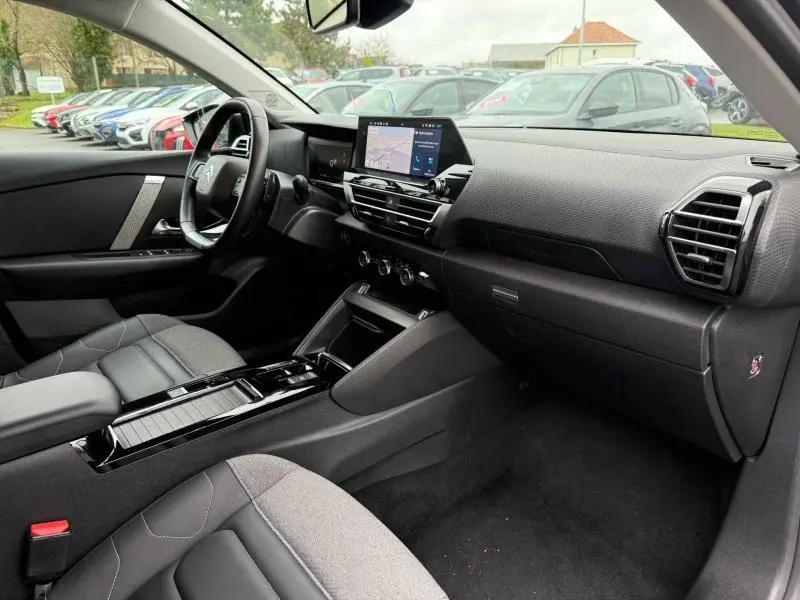 Vue intérieure côté conducteur de la Citroën C4 X 2024 avec tableau de bord moderne et écran tactile central.