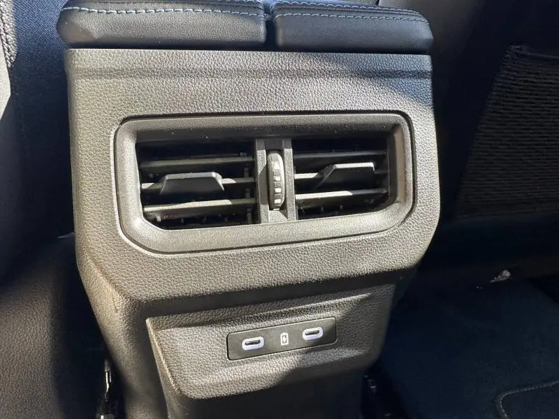 Détail de la console arrière noire avec bouches d’aération et ports USB du Renault Rafale 1.2 E-Tech 2025 bleu Sommet.