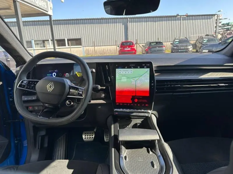 Vue intérieure avant du Renault Rafale bleu Sommet avec tableau de bord numérique et écran tactile central vertical.